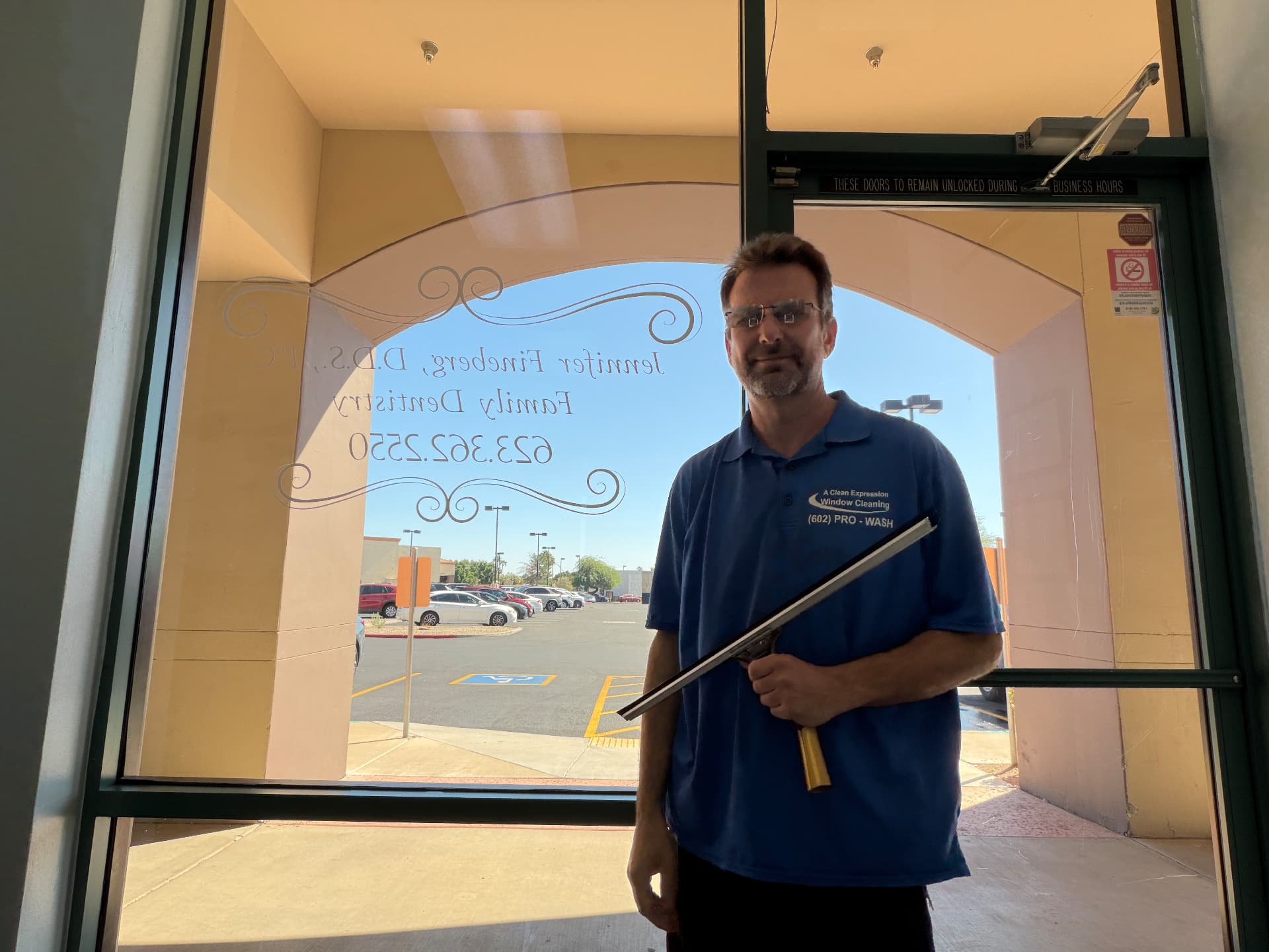 Steve Belcastro, owner of A Clean Expression Window Cleaning, with a squeegee at a Phoenix-area storefront